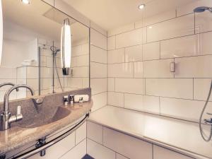 a bathroom with a sink and a shower at Mercure Hotel Saarbrücken Süd in Saarbrücken