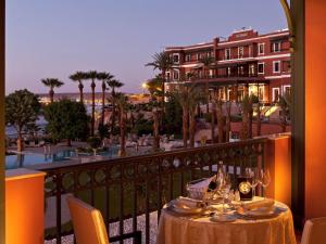 a table on a balcony with a view of a resort at Sofitel Legend Old Cataract in Aswan