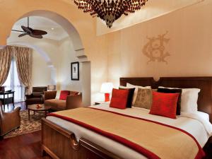 a bedroom with a large bed and a living room at Sofitel Legend Old Cataract in Aswan