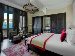 um quarto com uma cama grande e um lustre em Sofitel Legend Old Cataract em Aswan