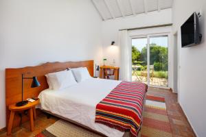 a bedroom with a bed and a sliding glass door at Abacatus Farmhouse in Tavira +64 photos
