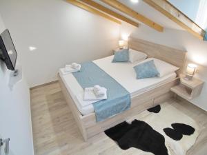 a bedroom with a large bed with blue pillows at Apartments Sweet Escape in Dubrovnik