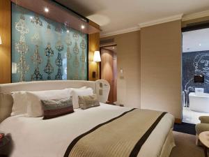 
a bedroom with a large bed and a large window at Sofitel Legend The Grand Amsterdam in Amsterdam
