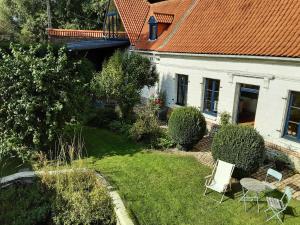 ein Haus mit zwei Stühlen und einem Tisch im Hof in der Unterkunft La grange de Fermont in Capelle-Fermont