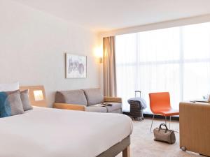 a hotel room with a bed and a couch at Novotel Genève Centre in Geneva