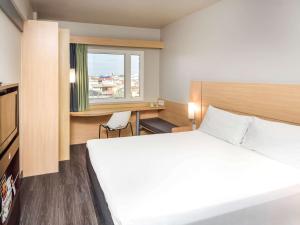 a hotel room with a large bed and a window at ibis Aracaju in Aracaju