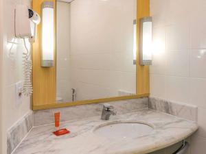 a bathroom with a sink and a mirror at ibis Aracaju in Aracaju