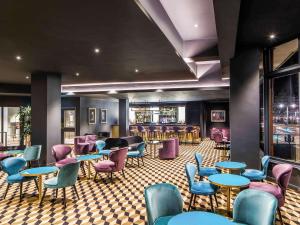 a restaurant with blue tables and purple chairs at Mercure Edinburgh City - Princes Street Hotel in Edinburgh