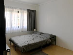 a bedroom with a bed and a window at เจริญพาณิชย์ รูมส์ in Pathum Thani