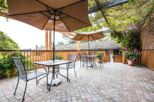 
a patio area with chairs, tables, and umbrellas at Clarion Collection Carmel Oaks Inn in Carmel
