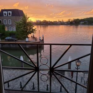 a view of a lake at sunset from a balcony at All Exclusive Apartments in Dordrecht