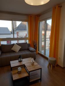 un soggiorno con divano e tavolo di magnifique appartement 3 étoiles centre ville et mer à pied a Saint-Brévin-les-Pins