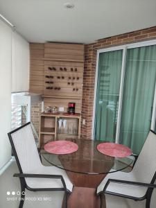 a dining room with a table and two chairs at Residencial Estanconfort Santos in Santos +6 photos