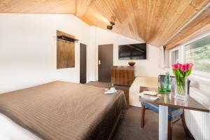 a bedroom with a bed and a table with flowers on it at Hotel U Šuláka in Brno