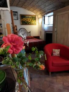 ein Schlafzimmer mit einem roten Sofa und einem roten Stuhl in der Unterkunft Romantic loft in Pitigliano