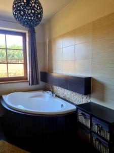 a bath tub in a bathroom with a window at Zacisze Jurajskie in Olsztyn