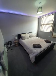 a bedroom with a bed with two brown shoes on it at 159 Smart Apartments in Newark-on-Trent