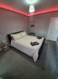 a bedroom with a bed with a red light on it at 159 Smart Apartments in Newark-on-Trent