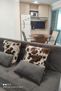 un sofá gris con almohadas en la cocina en Residencial Estanconfort Santos en Santos