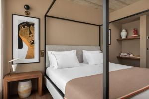 a bedroom with a four poster bed with white pillows at Dorma Essenzia Porto in Porto +41 photos