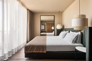 波尔图Exe Essenzia Porto的带一张大床和一面镜子的卧室