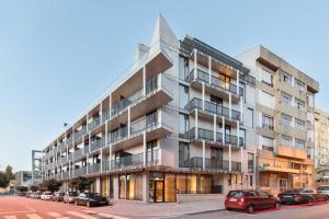 un edificio de apartamentos con coches estacionados frente a él en Exe Essenzia Porto en Oporto