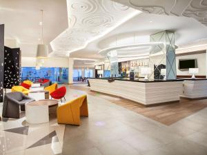 a lobby with a waiting area with colorful furniture at ibis Styles Bandung Grand Central in Bandung