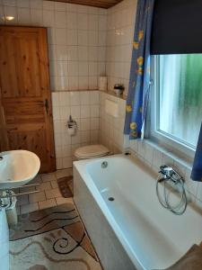 een badkamer met een bad, een toilet en een wastafel bij Gästehaus Rüger in Birkenau