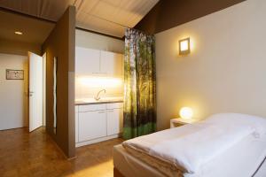 ein Schlafzimmer mit einem Bett und einem Waschbecken darin in der Unterkunft Gästeresidenz PelikanViertel in Hannover