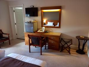 a hotel room with a desk and a mirror at Hillcrest Guest House in Clonmel