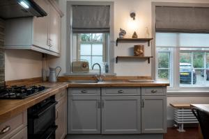 a kitchen with a sink and a stove at Tan Y Cytiau in Holyhead