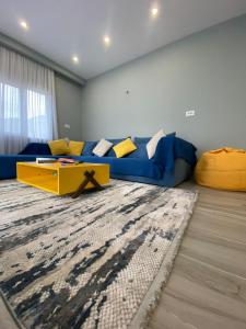 a living room with a blue couch and a yellow table at Villa Ermis in Dhërmi