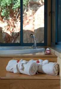 uma pilha de toalhas sentadas num balcão de madeira ao lado de um lavatório em Darna bagalil Chardonnay suite Perfect for couples em Lavon