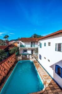a swimming pool in the backyard of a house at Pousada Rafimar in Ilhabela