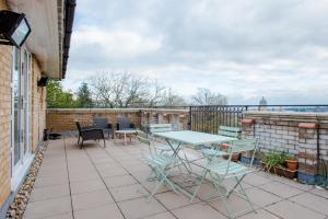 a patio with a table and chairs on a balcony at The Sparkford Gardens - Lovely 2BDR with Balcony in London
