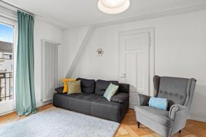 a living room with a couch and a chair at Central Bright & Cozy Apartments in Lucerne
