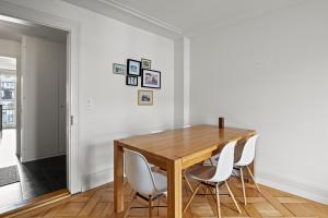 a dining room with a wooden table and white chairs at Central Bright & Cozy Apartments in Lucerne