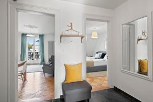 a living room with a chair and a bedroom at Central Bright & Cozy Apartments in Lucerne