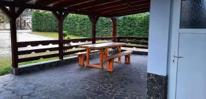 een picknicktafel en banken onder een paviljoen bij Cazare Luxandra in Borşa