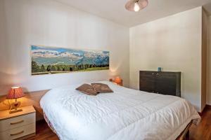 1 dormitorio con 1 cama y una pintura en la pared en Apartment center Madonna di Campiglio EM, en Madonna di Campiglio