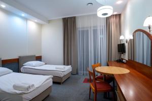 a hotel room with two beds and a table at Hotel Lord Gorlice in Gorlice