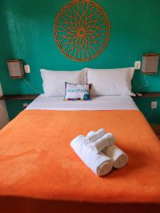 Pousada Astral في إيمبيتوبا: غرفة نوم عليها سرير وفوط