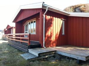 a red house with a porch and stairs to it at Sandvika Camping in Kabelvåg