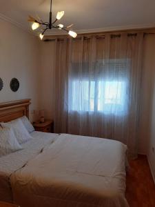 sypialnia z białym łóżkiem i oknem w obiekcie Mirador del Mar w mieście Arenales del Sol