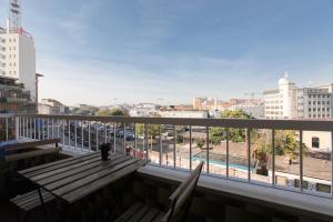 een balkon met een houten bank en uitzicht op de stad bij DADA 2bd App - nuovo in CENTRO zona Navigli in Milaan