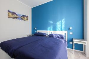 a blue bedroom with a bed and a blue wall at DADA 2bd App - nuovo in CENTRO zona Navigli in Milan