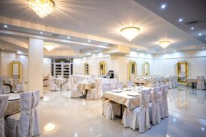 a banquet hall with white tables and chairs and chandeliers at Hotel Lord Gorlice in Gorlice