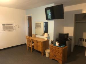 Cette chambre dispose d'un bureau et d'une télévision murale. dans l'établissement Cindy’s Motel & RV Park, à Mayo