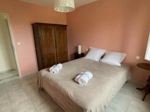 1 dormitorio con 1 cama con toallas en Les Jardins de Maelle, en Belvès