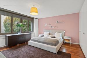 a bedroom with a bed and a large window at Large, central, bright flat in Lucerne